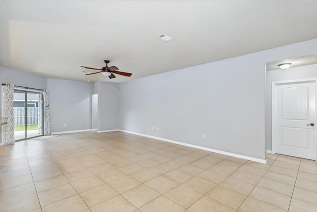 empty room featuring visible vents, a ceiling fan, baseboards, and light tile patterned floors