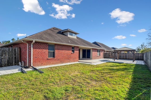 rear view of house with brick siding, a gazebo, a fenced backyard, and a patio area