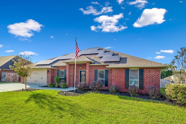 ranch-style house featuring driveway, brick siding, roof mounted solar panels, a front lawn, and an attached garage