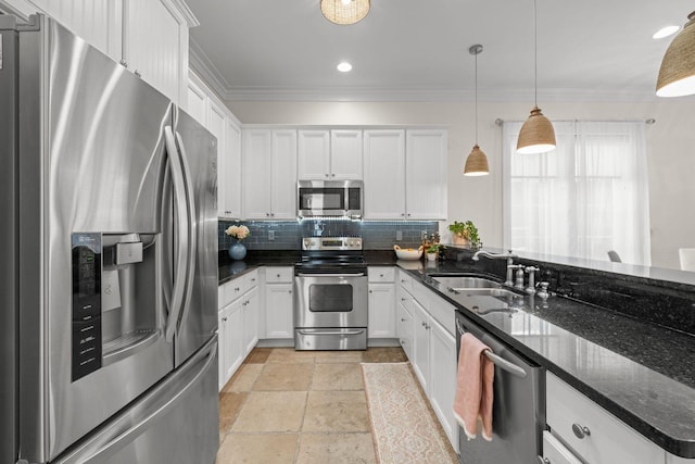 132 Carson Oaks Ln, Santa Rosa Beach, FL 32459 - kitchen featuring ornamental molding, white cabinets, tasteful backsplash, a sink, and appliances with stainless steel finishes