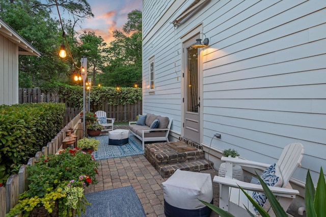 132 Carson Oaks Ln, Santa Rosa Beach, FL 32459 - patio terrace at dusk with an outdoor hangout area and a fenced backyard