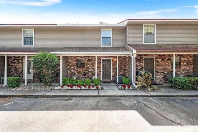229 Carmel Dr Unit 4, Fort Walton Beach, FL 32547 - view of front of property featuring a porch, brick siding, uncovered parking, and cooling unit