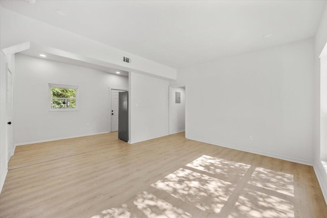unfurnished living room featuring baseboards, wood finished floors, and visible vents