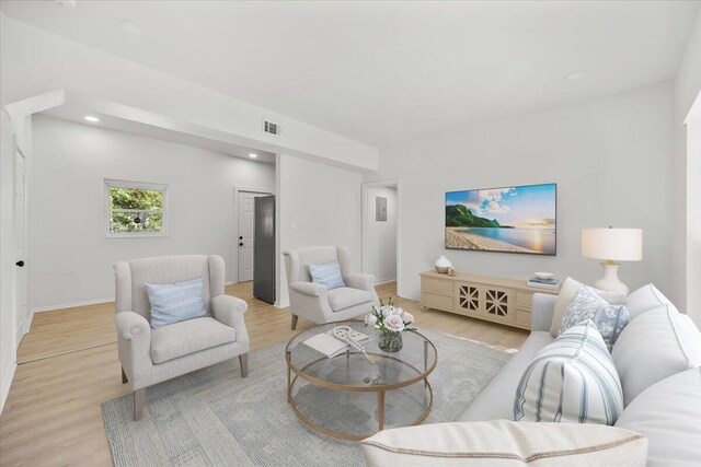 living area featuring recessed lighting, baseboards, visible vents, and light wood-style flooring
