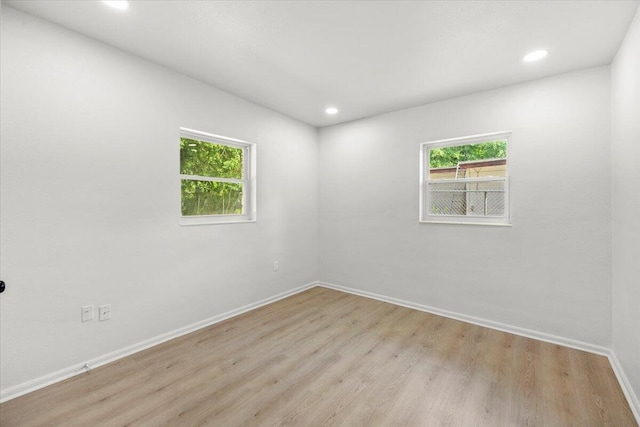 empty room featuring recessed lighting, baseboards, and light wood-type flooring