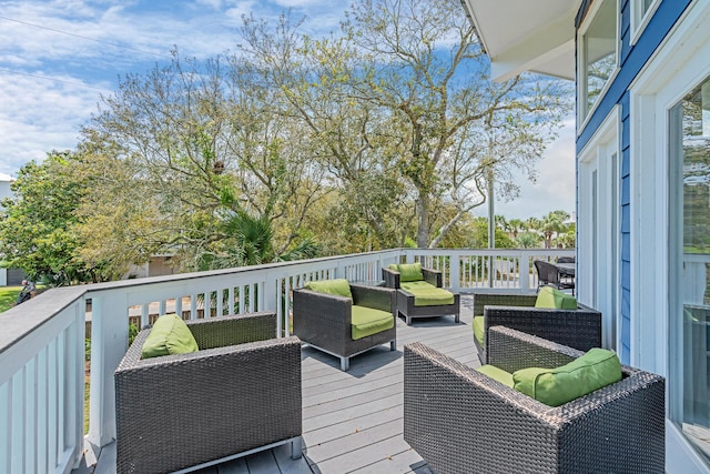 wooden terrace with an outdoor living space