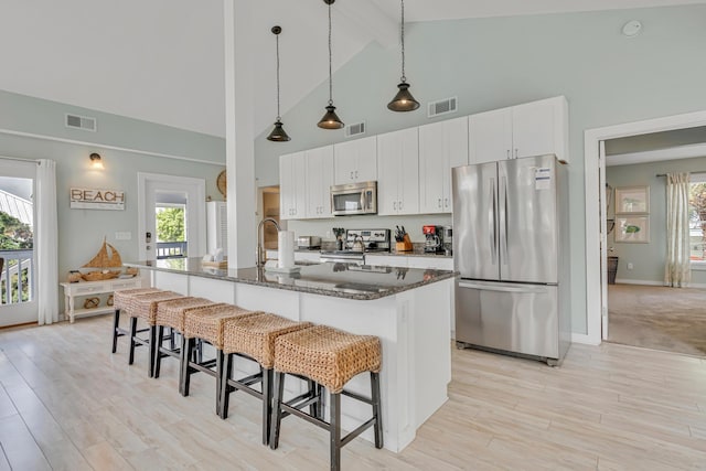 kitchen with visible vents, a kitchen breakfast bar, and stainless steel appliances
