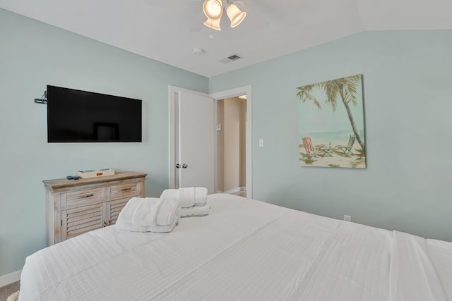 bedroom with baseboards, vaulted ceiling, and visible vents