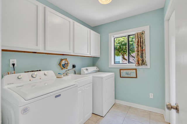 washroom featuring baseboards, cabinet space, light tile patterned floors, and washing machine and dryer