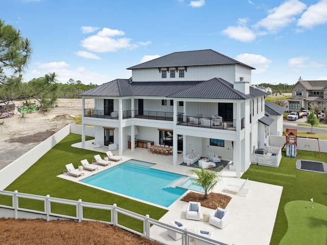 back of property with a fenced backyard, outdoor lounge area, and a balcony