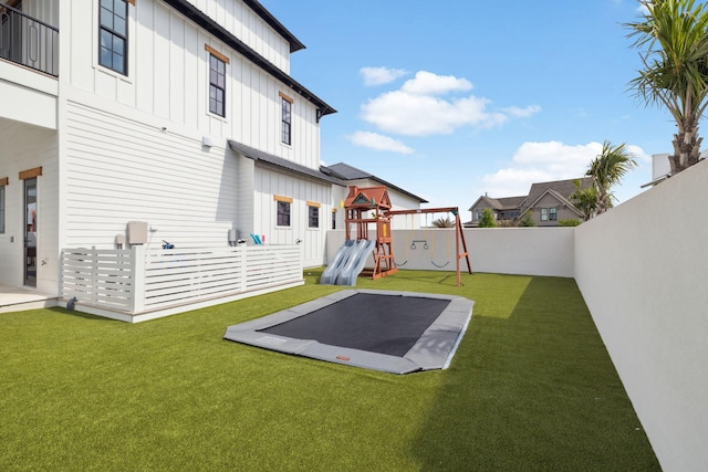 exterior space with a lawn, a fenced backyard, board and batten siding, and a playground