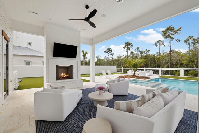 view of patio featuring an in ground hot tub, fence, an outdoor living space with a fireplace, and a fenced in pool