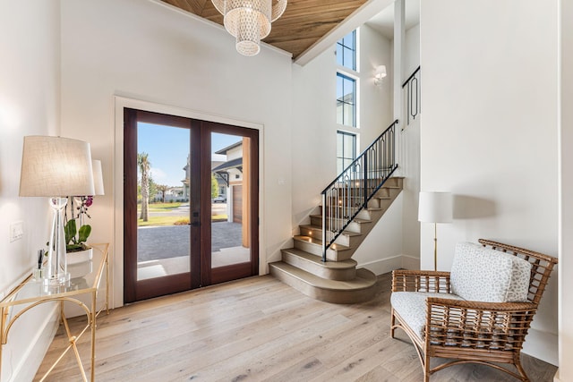 doorway featuring french doors, baseboards, wood finished floors, and stairway
