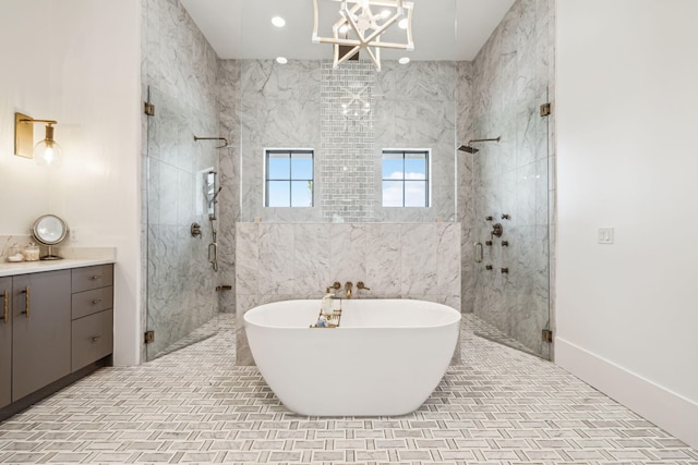 bathroom featuring vanity, a freestanding tub, a notable chandelier, and a shower stall