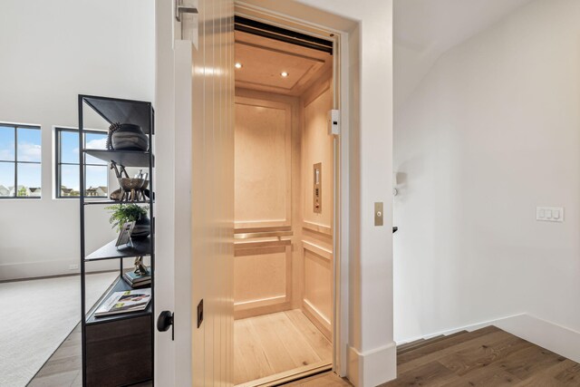 room details with recessed lighting, baseboards, elevator, and wood finished floors
