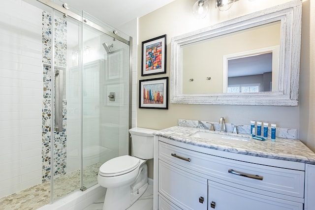 bathroom featuring vanity, toilet, and a stall shower