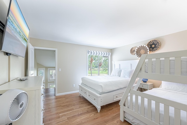 bedroom featuring baseboards, multiple windows, and light wood-type flooring