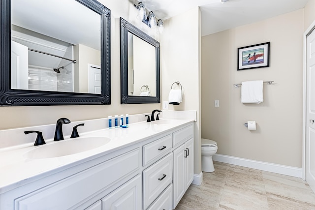 full bath with toilet, double vanity, baseboards, and a sink