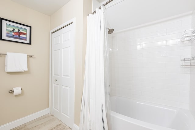 bathroom with baseboards and shower / bath combination with curtain