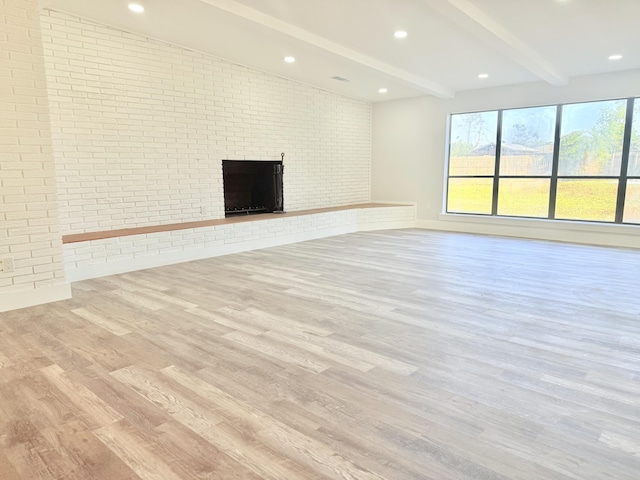 2710 Rutgers Dr, Panama City, FL 32405 - unfurnished living room featuring lofted ceiling with beams, wood finished floors, recessed lighting, a brick fireplace, and brick wall