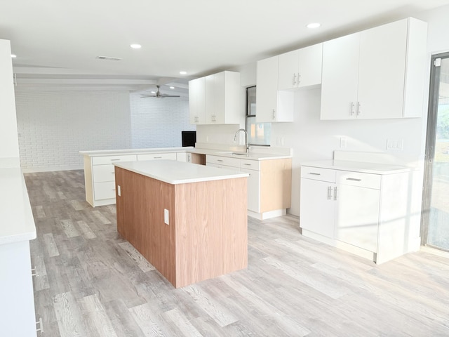 2710 Rutgers Dr, Panama City, FL 32405 - kitchen with a peninsula, white cabinetry, visible vents, ceiling fan, and light wood-style floors