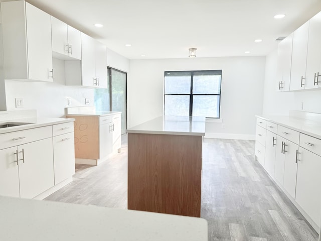 2710 Rutgers Dr, Panama City, FL 32405 - kitchen with recessed lighting, light wood-style flooring, light countertops, a center island, and white cabinets