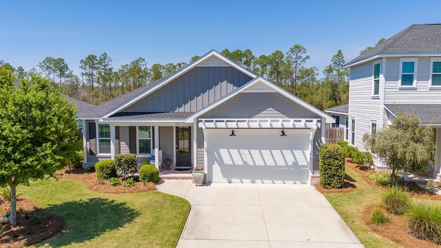 craftsman house featuring board and batten siding, an attached garage, concrete driveway, and a front lawn