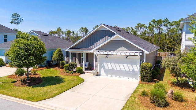 craftsman-style home with board and batten siding, roof with shingles, a front yard, concrete driveway, and an attached garage