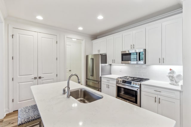 kitchen with crown molding, a sink, stainless steel appliances, white cabinetry, and tasteful backsplash