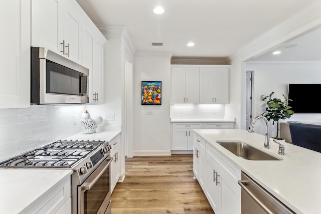 kitchen featuring white cabinets, appliances with stainless steel finishes, a sink, and visible vents