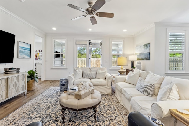 living room featuring plenty of natural light, ornamental molding, and wood finished floors