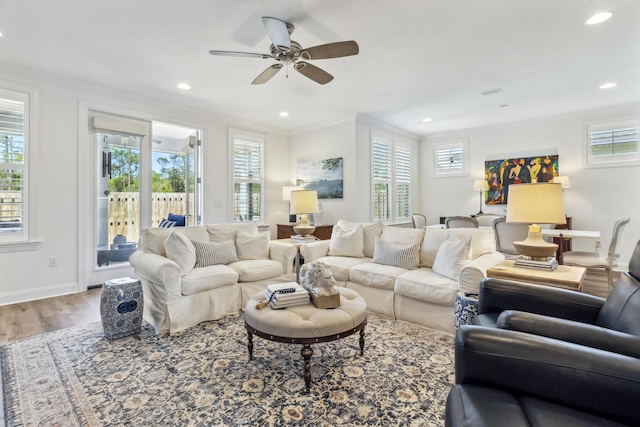 living room with plenty of natural light, crown molding, and wood finished floors