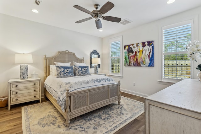 bedroom with visible vents, recessed lighting, wood finished floors, and multiple windows