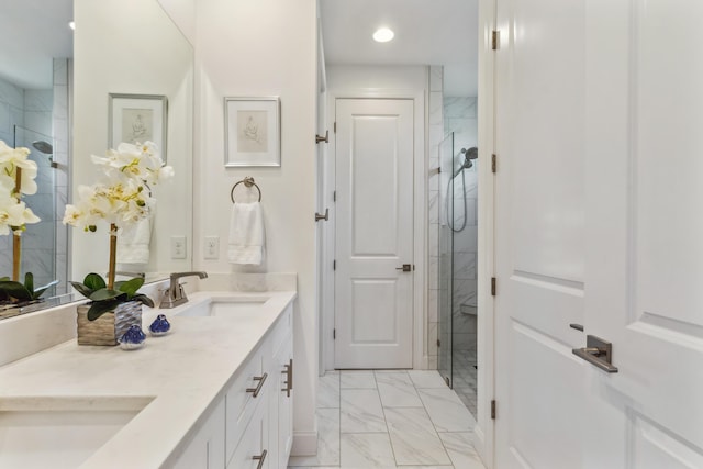 full bath with double vanity, a shower stall, a sink, marble finish floor, and recessed lighting