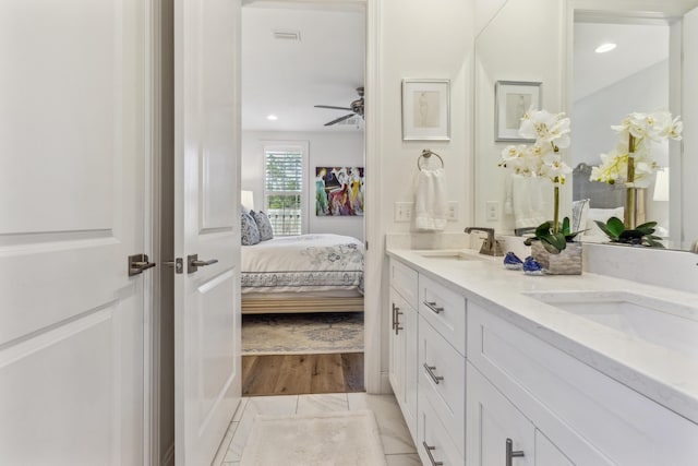 bathroom with a sink, ensuite bathroom, double vanity, and ceiling fan