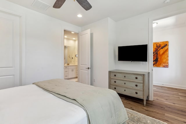 bedroom featuring visible vents, wood finished floors, baseboards, ensuite bathroom, and recessed lighting
