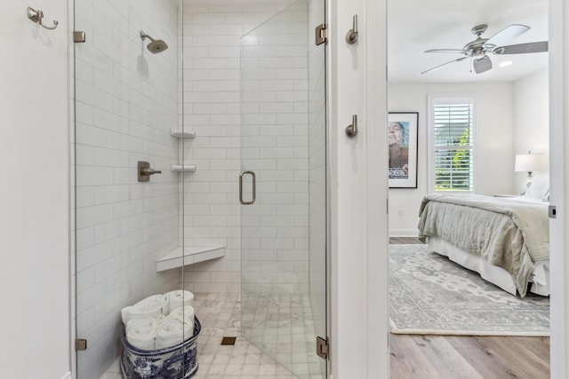 bathroom featuring a ceiling fan, connected bathroom, wood finished floors, and a shower stall