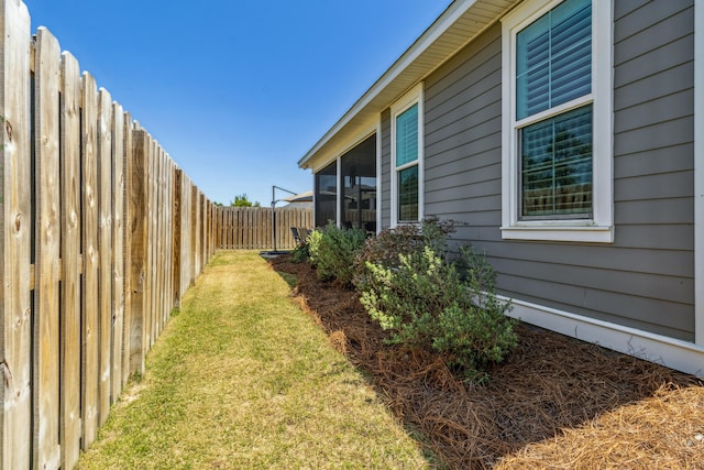 view of yard featuring a sunroom and a fenced backyard