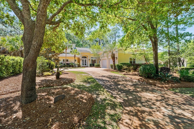 2928 Pine Valley Dr, Miramar Beach, FL 32550 - view of front of house featuring an attached garage, stucco siding, driveway, and a chimney