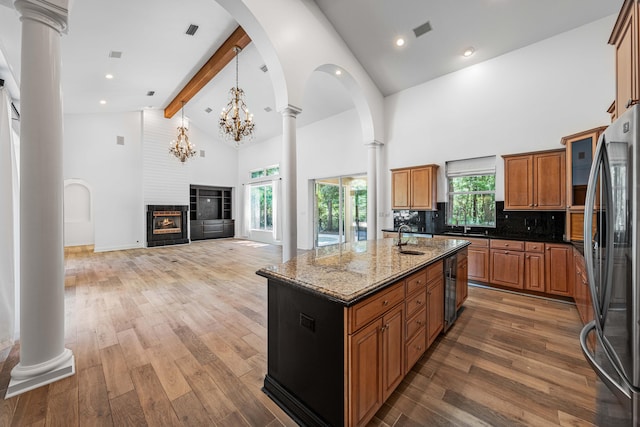 2928 Pine Valley Dr, Miramar Beach, FL 32550 - kitchen featuring brown cabinets, stainless steel fridge, beam ceiling, high vaulted ceiling, and ornate columns
