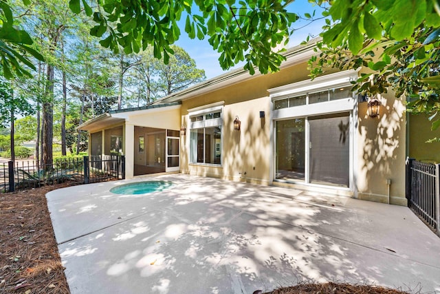2928 Pine Valley Dr, Miramar Beach, FL 32550 - back of property featuring fence, a hot tub, stucco siding, a sunroom, and a patio