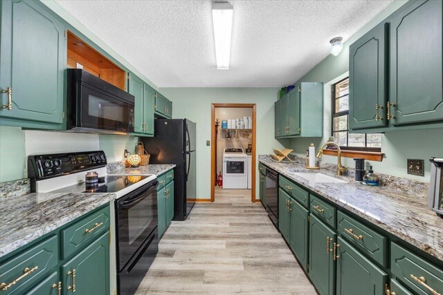 612 Moss Dr, Crestview, FL 32536 - kitchen with a sink, a textured ceiling, washer / dryer, light wood-type flooring, and black appliances