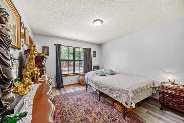 612 Moss Dr, Crestview, FL 32536 - bedroom with baseboards, a textured ceiling, and light wood finished floors