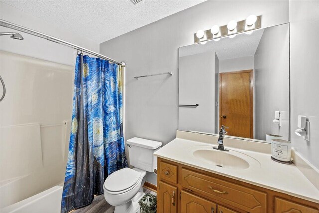 612 Moss Dr, Crestview, FL 32536 - bathroom with a textured ceiling, wood finished floors, shower / tub combo, vanity, and toilet