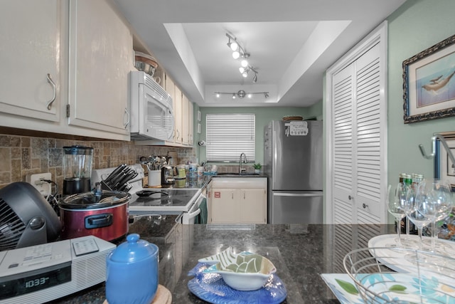 909 Santa Rosa Blvd Unit 241, Fort Walton Beach, FL 32548 - kitchen featuring white appliances, dark stone counters, white cabinets, a tray ceiling, and a sink