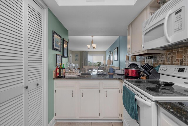 909 Santa Rosa Blvd Unit 241, Fort Walton Beach, FL 32548 - kitchen featuring tasteful backsplash, light tile patterned floors, an inviting chandelier, white appliances, and white cabinetry