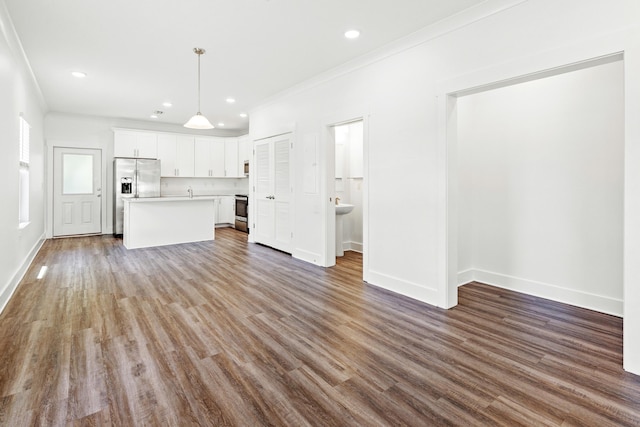 unfurnished living room featuring crown molding, wood finished floors, recessed lighting, and baseboards