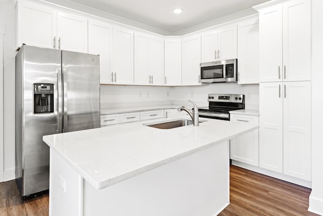 kitchen with stainless steel appliances, a sink, dark wood finished floors, white cabinetry, and an island with sink