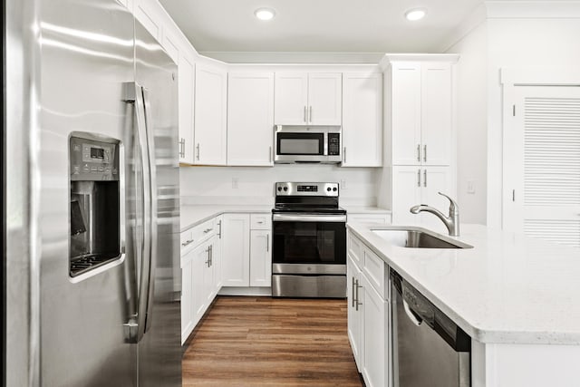 kitchen featuring stainless steel appliances, a sink, white cabinetry, recessed lighting, and dark wood-type flooring