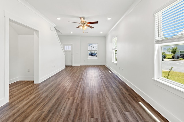 unfurnished living room featuring plenty of natural light, ceiling fan, dark wood-type flooring, recessed lighting, and ornamental molding
